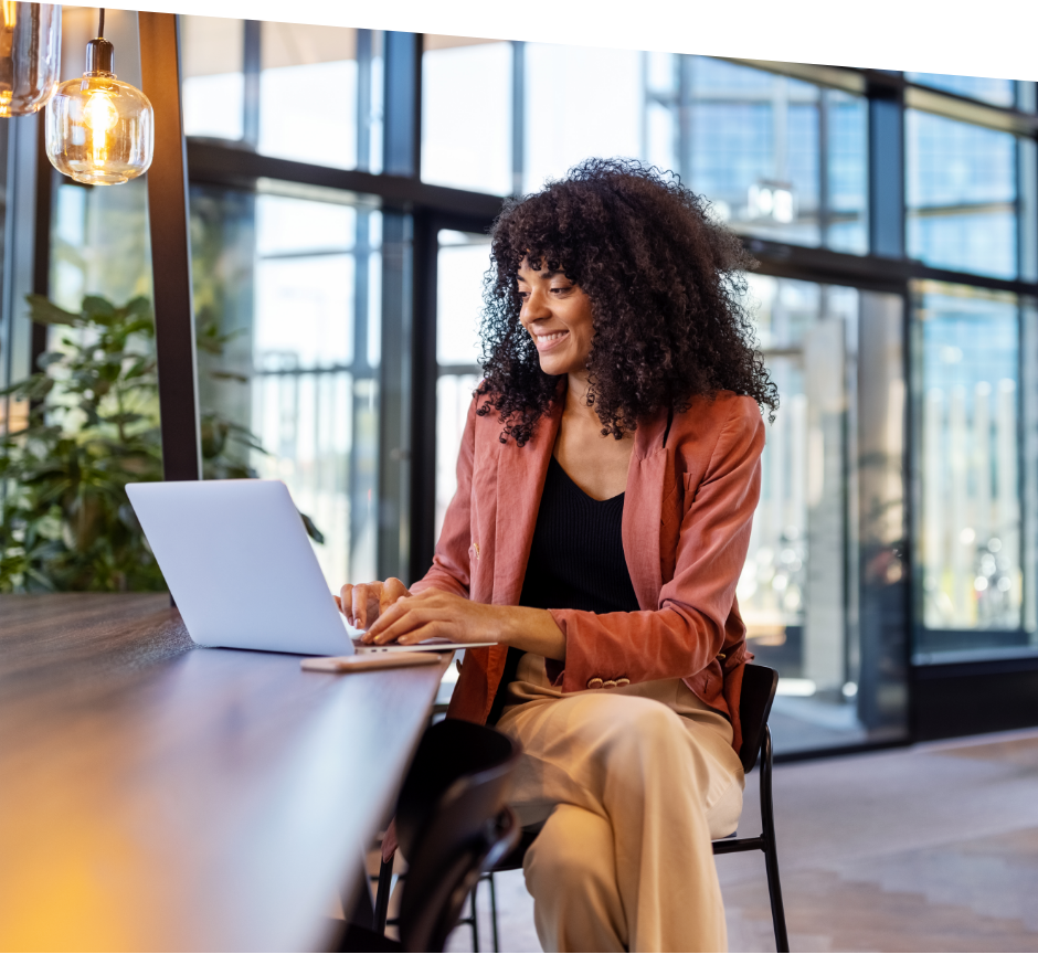woman in an office building typing on a laptop