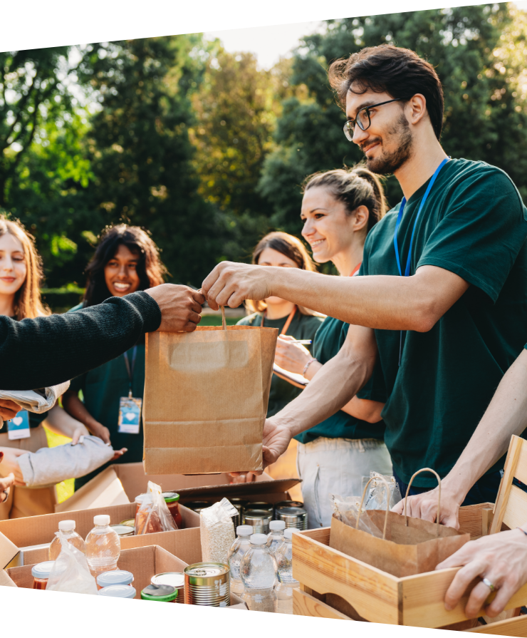 a man handing out a bag of food